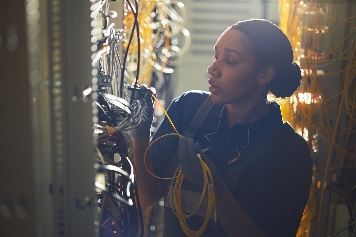 Engineer wiring network cables in a server room