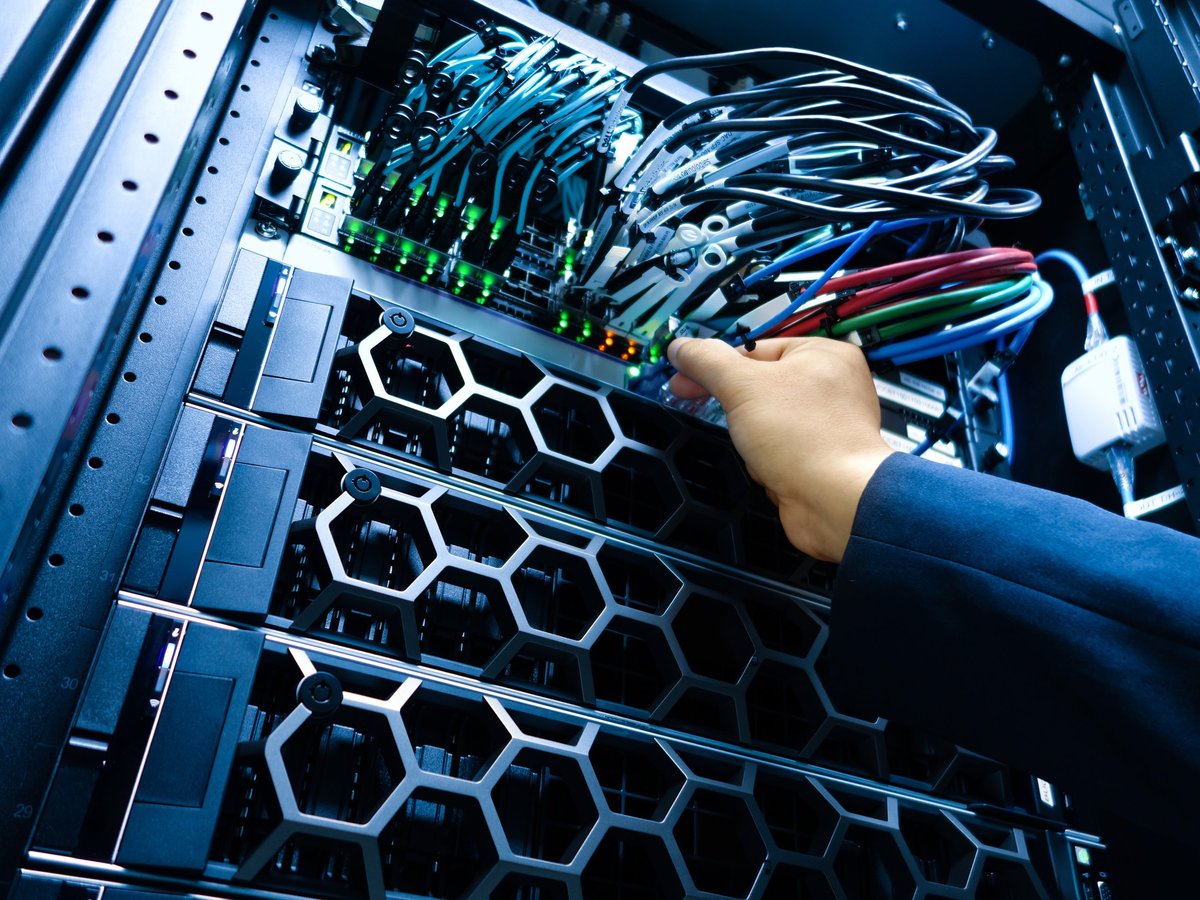 ALYAFTECH technician performing maintenance on a server rack and managing cables